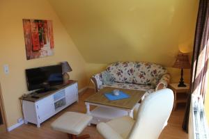 ein Wohnzimmer mit einem Sofa und einem TV in der Unterkunft Apartmenthaus Padua in Büsum