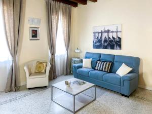 eine blaue Couch und ein Stuhl im Wohnzimmer in der Unterkunft Juliet House in Verona