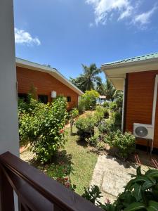 a balcony of a house with bushes and flowers at Anse Grosse Roche Beach Villa in La Digue