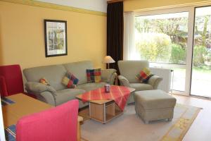 a living room with a couch and a table and chairs at Apartmenthaus Padua in Büsum