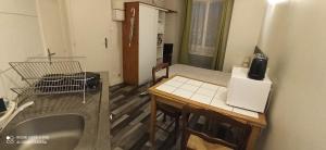 Una pequeña cocina con una mesa y un refrigerador. en studio1 Bagnères de Bigorre, en Bagnères-de-Bigorre