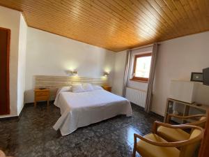 a bedroom with a white bed and a window at Hotel Rural Cal Amadeu in Vilanova de Escornalbou