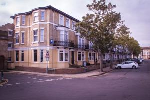 um edifício com um carro estacionado em frente em The Embassy Hotel em Great Yarmouth