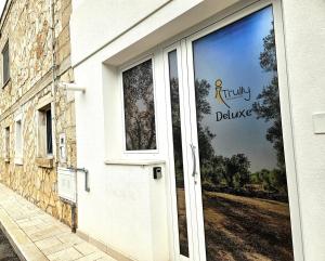 a white door with a sign that reads truly divine at Deluxe in Alberobello