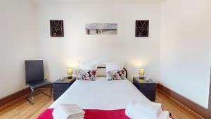 - une chambre avec un grand lit blanc et 2 tables de chevet dans l'établissement Les Cigognes d'Alsace, à Colmar
