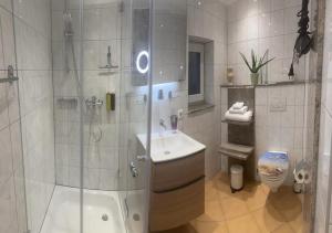 een badkamer met een douche, een wastafel en een toilet bij Exklusives Refugium- Privat-Boardinghouse Meerbusch - Ihre Oase nahe der Messe Düsseldorf in Meerbusch