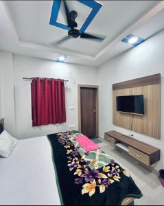 a bedroom with a bed and a tv on the wall at Paradise residency and cafe in Gwalior