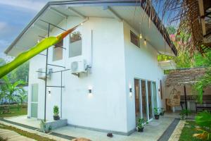 a white house with a large yellow bat at Villa DK in Kamburugamuwa