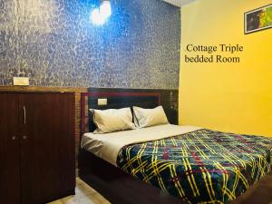 una camera con un letto in una stanza con un muro di MSP Amma Cottage a Munnar