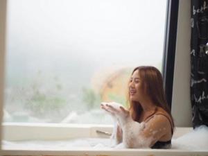 una donna seduta in una vasca da bagno con finestra di ม่อนตะวัน ม่อนแจ่ม a Mon Jam