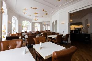 a dining room with white tables and chairs at Milling Hotel Saxildhus in Kolding