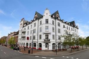 a white building on the corner of a street at Milling Hotel Saxildhus in Kolding