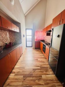 a kitchen with brown cabinets and a wooden floor at Morningside41 in Ongwediva