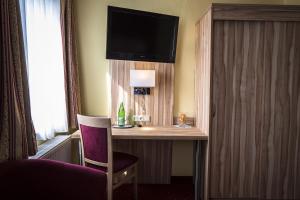 um quarto de hotel com uma secretária com uma cadeira e uma televisão em Hotel Weinhaus Kreuter em Koblenz