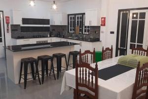 a kitchen with a table and some bar stools at Villa Silversands, Negombo in Negombo