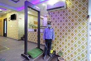 a man wearing a mask standing in front of a mirror at Hotel Star Inn - Delhi Airport, Mahipalpur, Aerocity in New Delhi