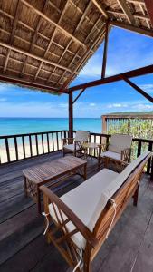 1 cama y 2 sillas en una terraza con vistas al océano en Layla Cottage Gành Đá Đĩa, en Tuy Hoa