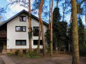 Biały dom z drzewami przed nim w obiekcie Nest 4 Rest w mieście Konstancin-Jeziorna