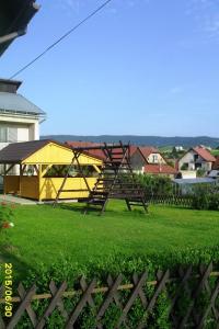 a swing set in a yard with a yellow tent at Penzión u Peťa in Hruštín