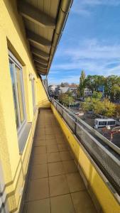 a balcony of a yellow building with a view of a street at Im Herzen der Dresdner Neustadt in Dresden