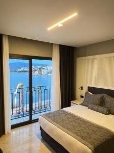 a bedroom with a bed and a view of the water at ROSEIRA MAR-INN LUXURY in Gulluk