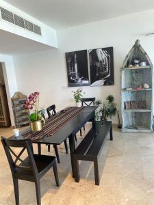 ein Esszimmer mit einem schwarzen Tisch und Stühlen in der Unterkunft Magical Marina View Sifah Resort in As Sīfah