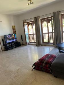 ein Wohnzimmer mit einem Sofa und einem Flachbild-TV in der Unterkunft Magical Marina View Sifah Resort in As Sīfah