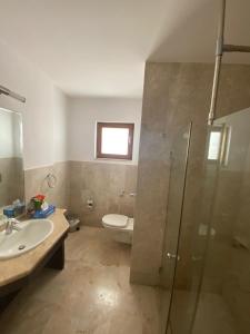 ein Bad mit einem WC, einem Waschbecken und einer Dusche in der Unterkunft Magical Marina View Sifah Resort in As Sīfah