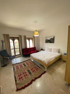 ein Schlafzimmer mit einem Bett und einem roten Sofa in der Unterkunft Magical Marina View Sifah Resort in As Sīfah