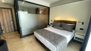 1 dormitorio con 1 cama grande y espejo grande en ROSEIRA MAR-INN LUXURY en Gulluk