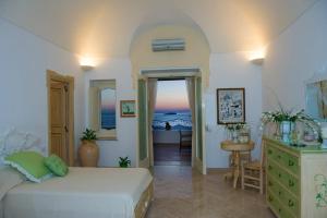 a bedroom with a bed and a dresser in a room at Villa Santa Chiara Positano Suites in Positano
