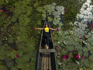 a woman standing on a rope bridge over a pond at Coconut Lagoon Kumarakom- CGH Earth in Kumarakom