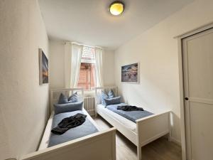 two beds in a small room with a window at Führs in Borkum