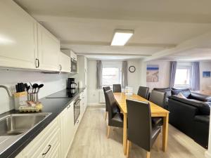 a kitchen and dining room with a table and a couch at Führs in Borkum