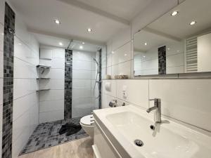 a white bathroom with a sink and a toilet at Führs in Borkum +14 photos