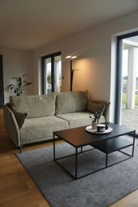 uma sala de estar com um sofá e uma mesa de centro em Ferienwohnung Abt Kleber em Bad Schussenried