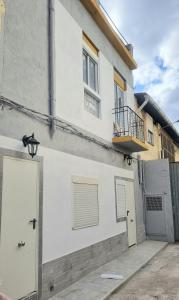 a white building with a door and a balcony at Apartamentos Aeropuerto Valencia in Manises