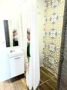 een badkamer met een witte wastafel en een spiegel bij Apartamentos Aeropuerto Valencia in Manises
