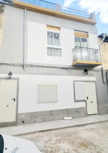 ein weißes Gebäude mit zwei Türen und einem Balkon in der Unterkunft Apartamentos Aeropuerto Valencia in Manises