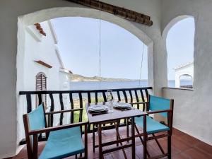 einen Tisch und Stühle auf einem Balkon mit Meerblick in der Unterkunft P107 Un rinconcito en el mar in Fornells