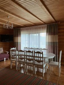 a dining room with a white table and chairs at Cottage Simka in Mykulychyn