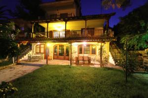 a house with a balcony and a yard at night at Aquamarine Apartments in Paleo Tsifliki