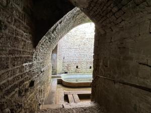 een boog in een bakstenen gebouw met een badkuip bij Domaine de Val combe in Dole +30 foto's
