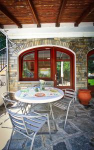 a patio with a table and chairs in front of a building at Aquamarine Apartments in Paleo Tsifliki