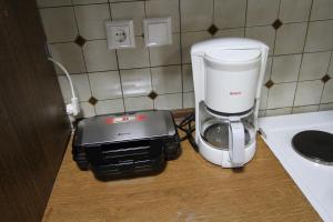 a coffee maker sitting on a counter next to a blender at Aquamarine Apartments in Paleo Tsifliki