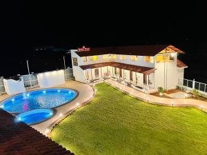 una casa con piscina por la noche en The Grand Leela Resort, en Khopoli