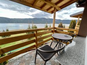a table and chairs on a porch with a view of a lake at ЕДЕЛВАЙС Сърница in Sarnitsa
