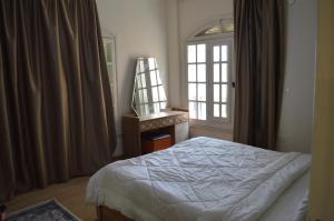 a bedroom with a bed and a dresser and a window at عقار العرب in 6th Of October