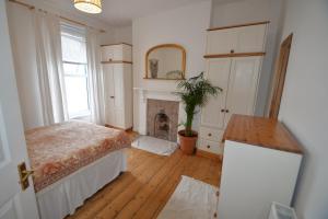 een slaapkamer met een bed en een open haard bij Bright and cosy, central 3 bedroom home in Plymouth