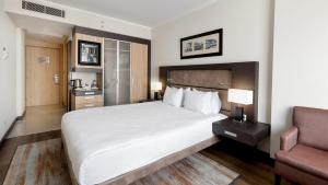a hotel room with a large bed and a chair at Vip Great Airport Hotel in Arnavutköy
